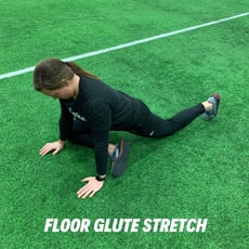 Orthopedic institute athletic trainer demonstrates the floor glute stretch to relieve low back pain.